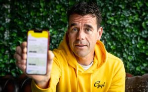 Cyql Founder holding phone Cycling Ireland adopts Cyql to digitalise Irish club experience